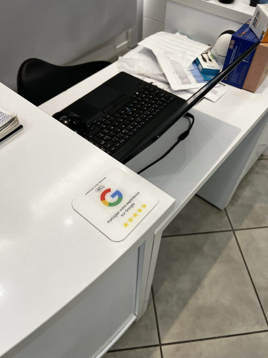 Plaque Avis Google posée sur le bureau d'accueil d'un commerce