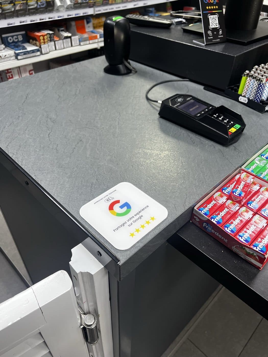 Plaque Avis Google sur le comptoir de caisse d'un bureau de tabac
